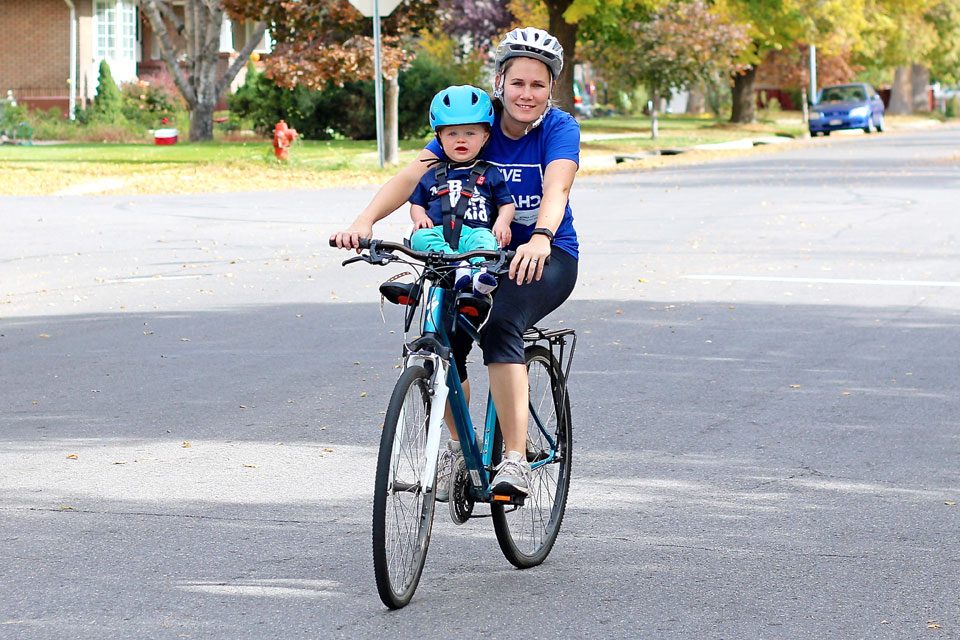 Mom riding bike with baby in Hamax Observer front mounted baby bike seat