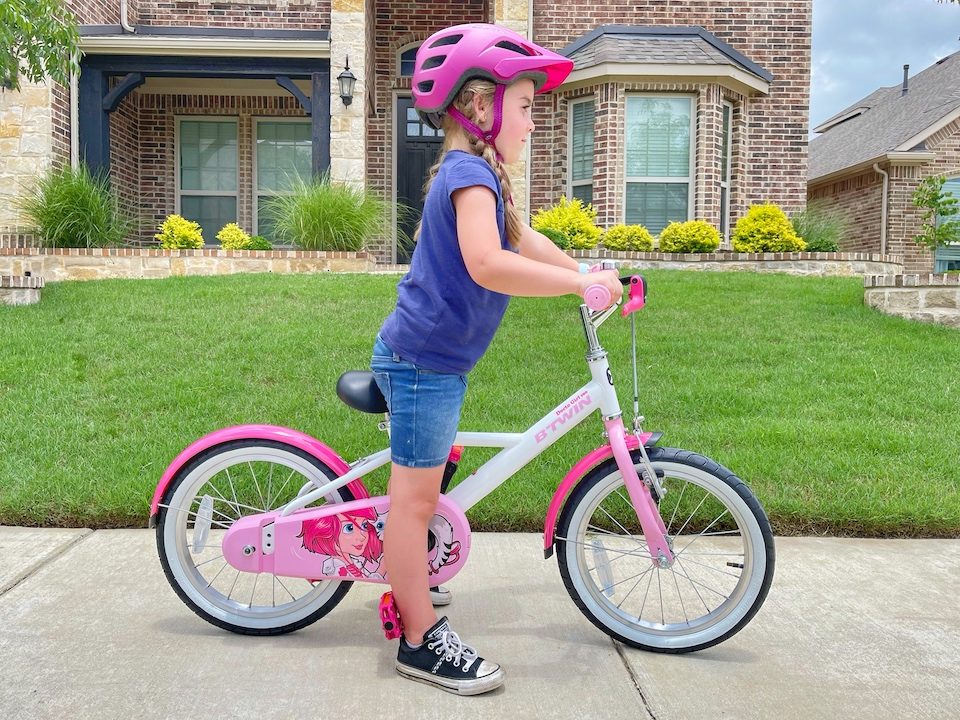 Child sitting on a bike with her feet flat and no bend in her knee