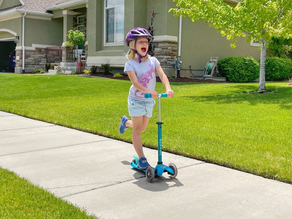 6 year old riding Micro Mini scooter on the sidewalk
