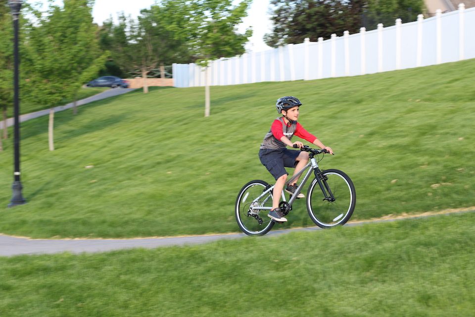Boy riding Prevelo Alpha Four up a paved hill