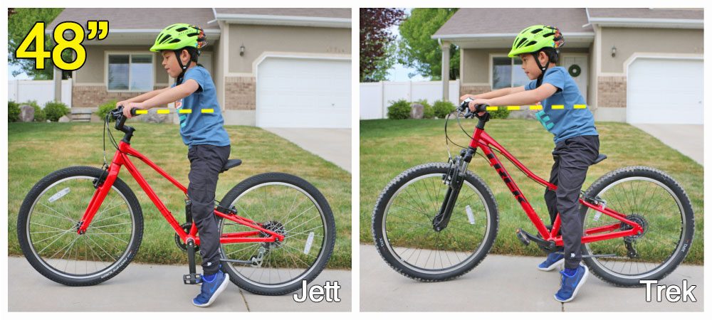 7 year old rider standing over the Specialized Jett 24 inch bike. the bike is too big for him