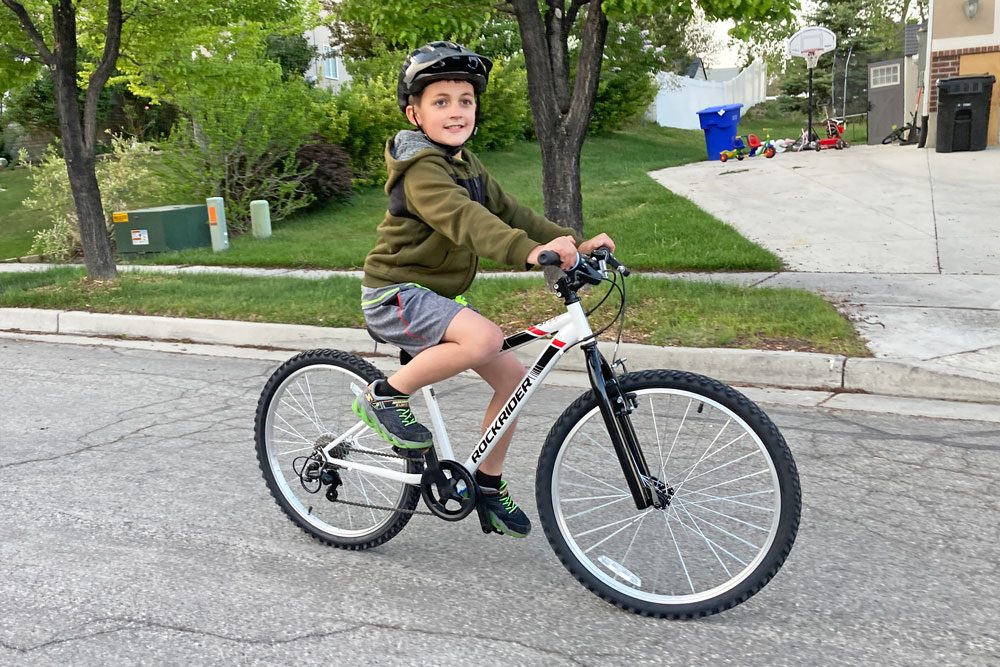 boy riding the btwin rockrider 24 in the neighborhood