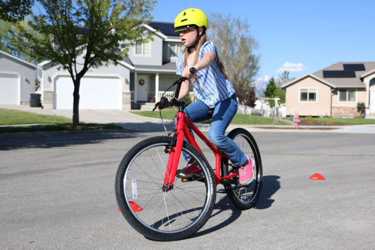 Girl riding Specialized Jett kids bike through cones