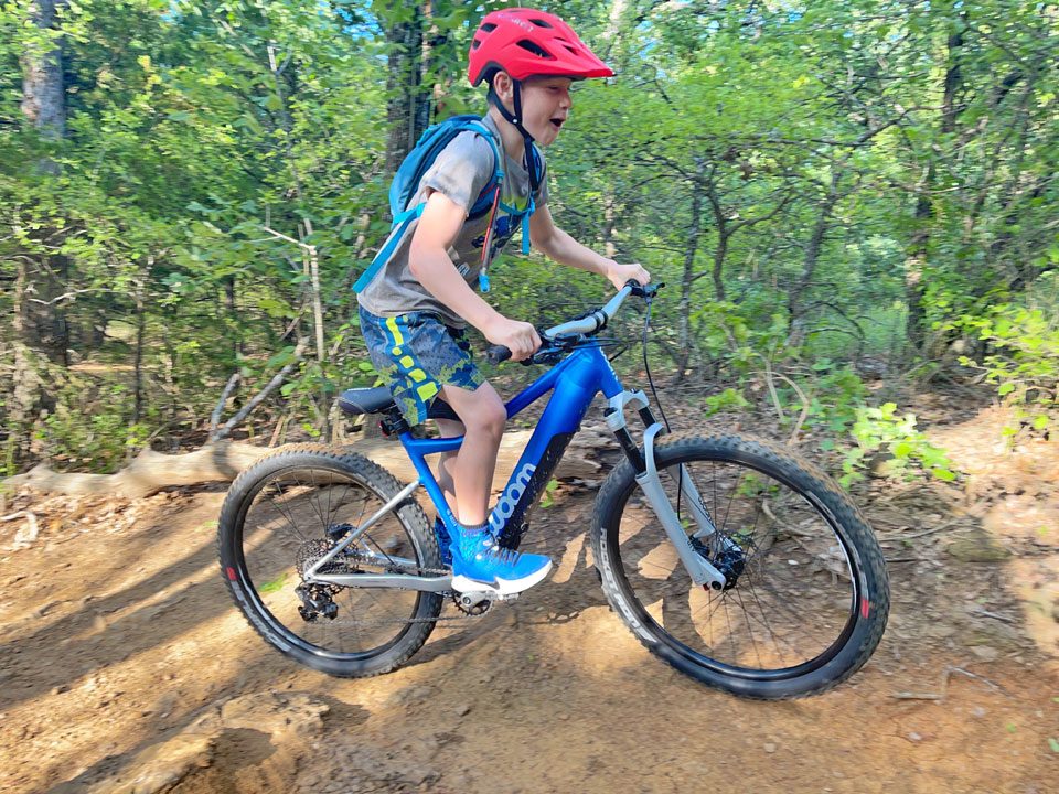 Boy smiling as he happily rides the woom UP kids ebike