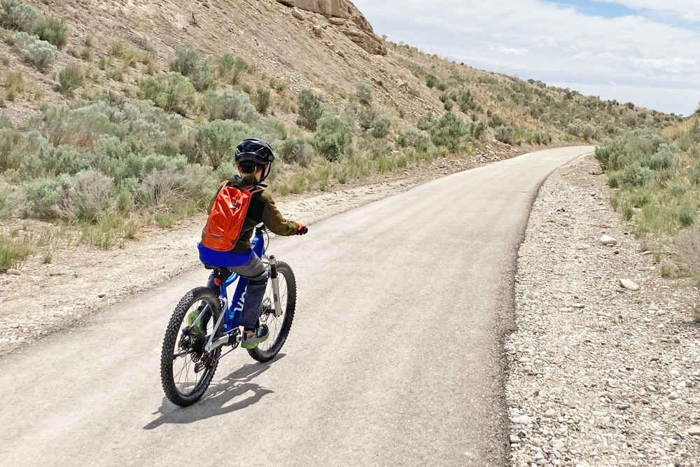 boy riding the woom UP 5 ebike on a paved trail