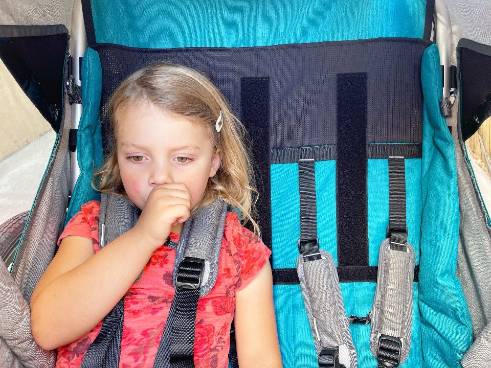 Tall three year old sitting in bike trailer