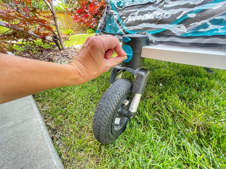 Pushing the blue button to engage the lock on the front wheel of the Speedkid