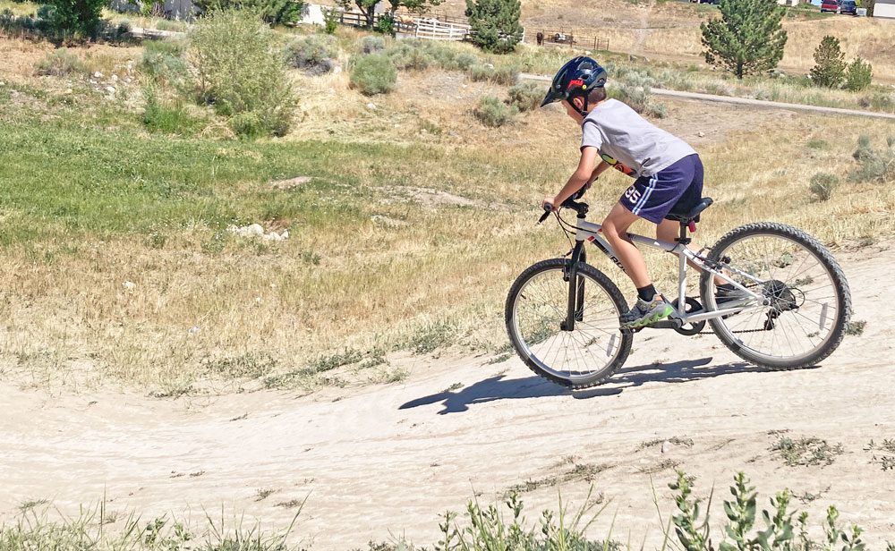 riding down a dirt hill on the btwin rockrider 24 kids bike
