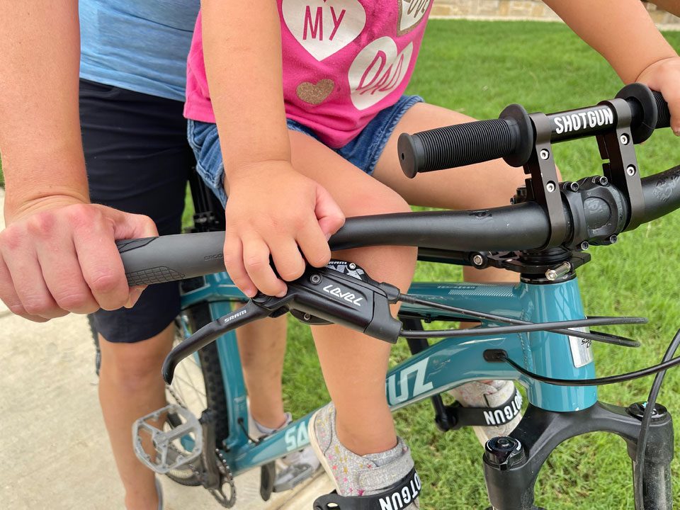 Turning handlebar with child scooted forward on seat causes the handlebar to hit child's knee