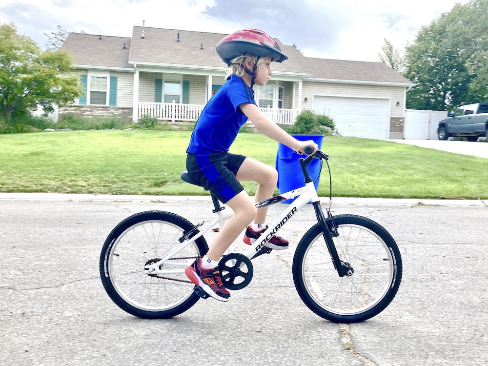 boy riding the rockrider 20 inch on a paved road