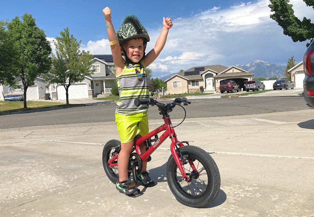 boy lifting up his hands in joy while sitting on the Cleary Gecko kids bike