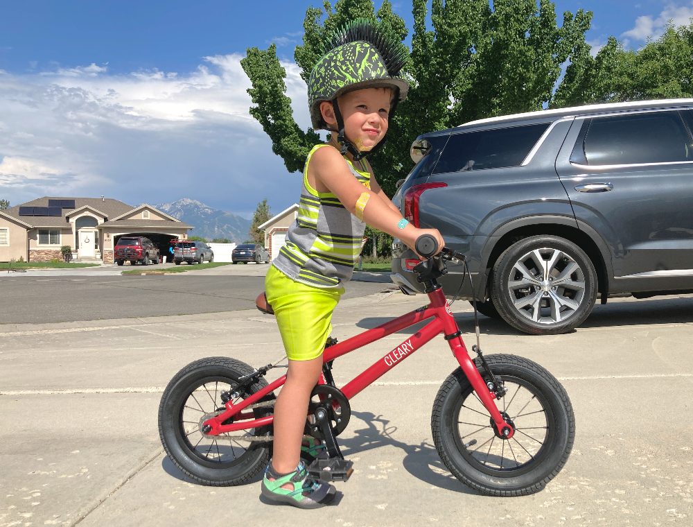 boy standing over the Cleary Gecko with his feet on the ground