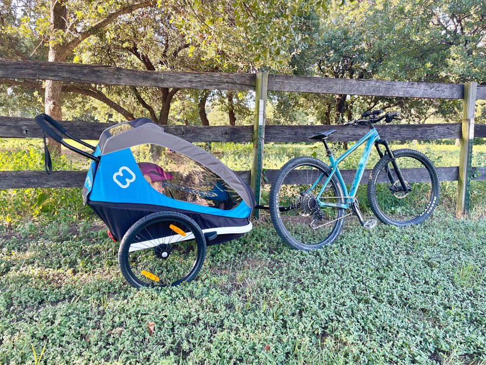 Hamax Traveller attached to mountain bike, leaning against a farm fence