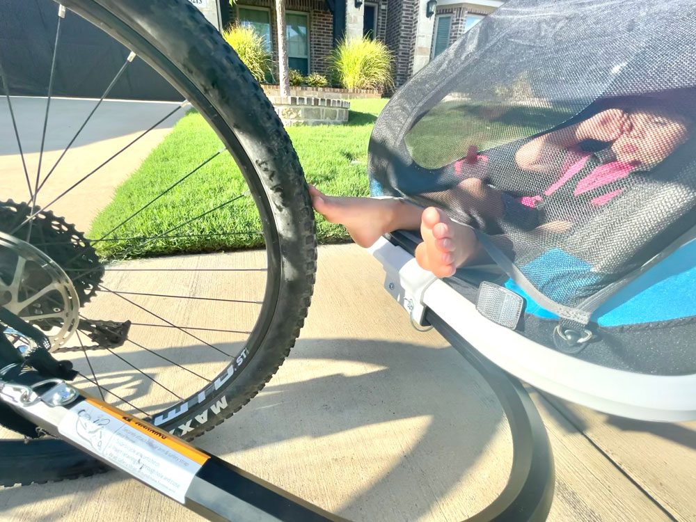 Toddlers toes reaching out of the Hamax Traveller and touching the rear wheel