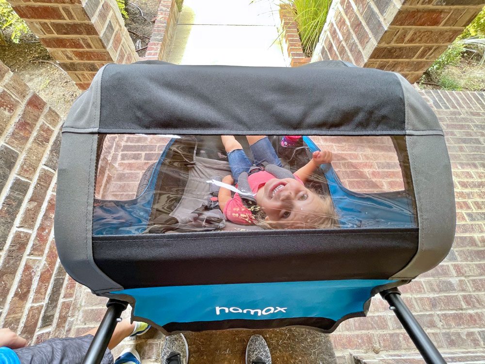 Toddler looking up through stroller viewing window of Hamax traveller