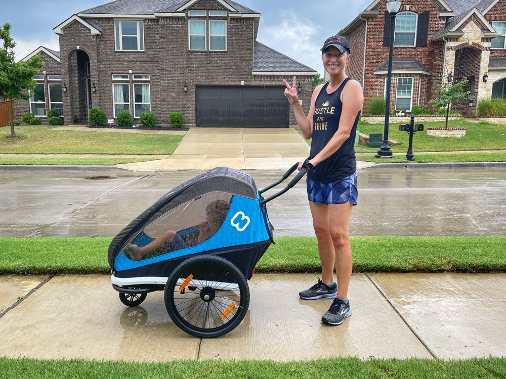 Mom pushing Hamax Traveller stroller in the rain