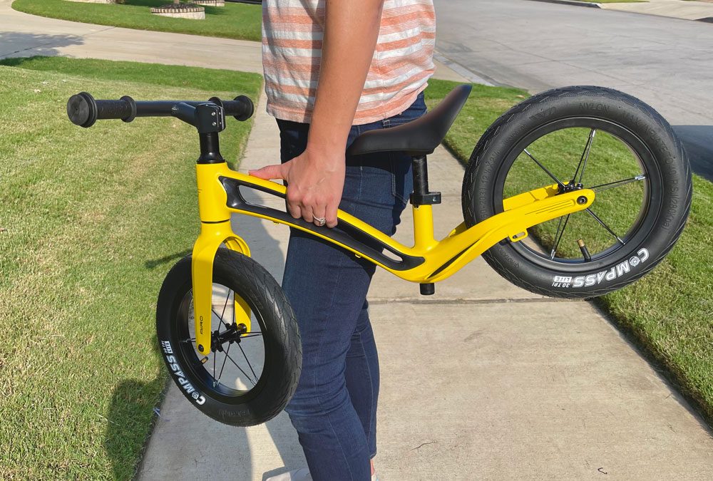 Mom carrying Hornit AIRO by its frame handlebar