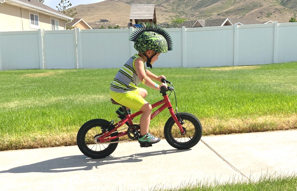 preschool boy riding the Clearly Gecko bike