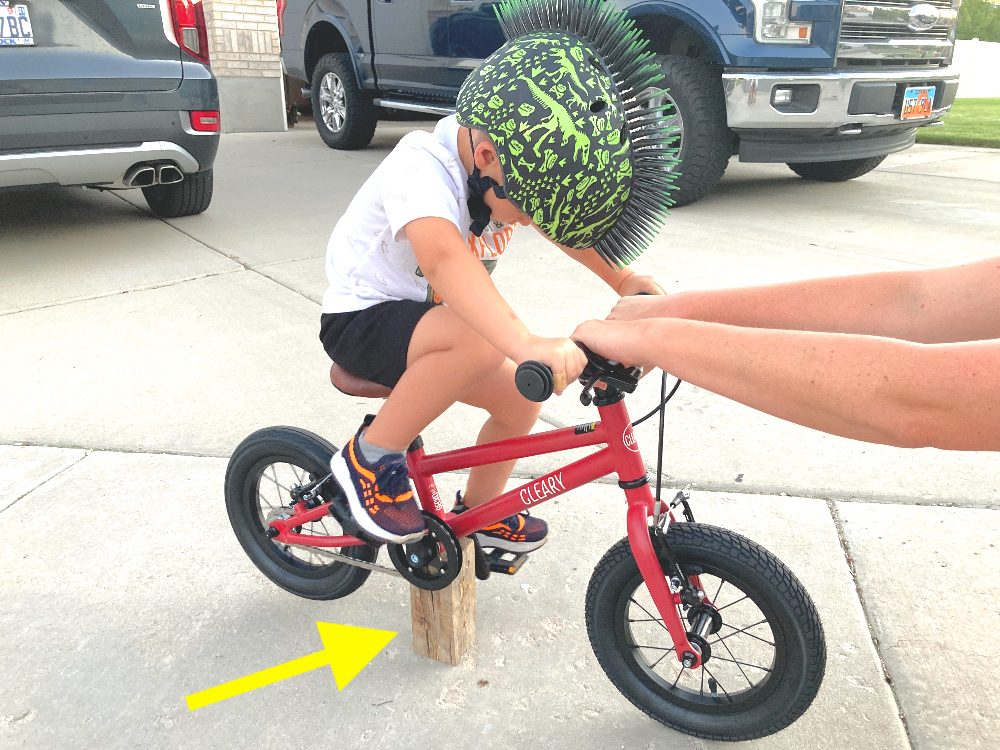 a boy riding the Cleary Gecko with the bike being propped up by a wood block