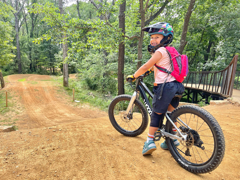 Young girl on woom OFF 4 about to start a downhill run