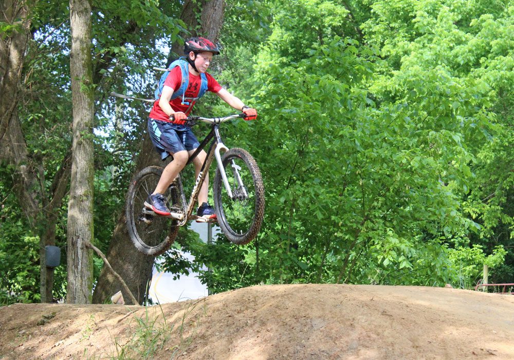 young rider catching air on the woom OFF kids mountain bike