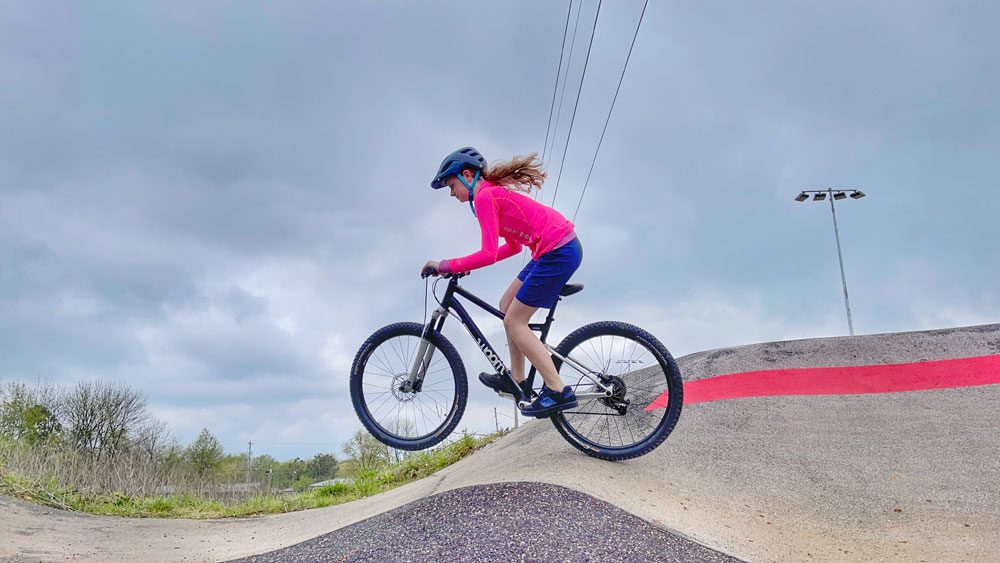 young rider jumping the woom OFF AIR 6 at a pump track