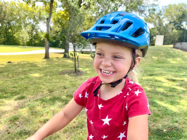 Child smiling and wearing Smith youth bike helmet