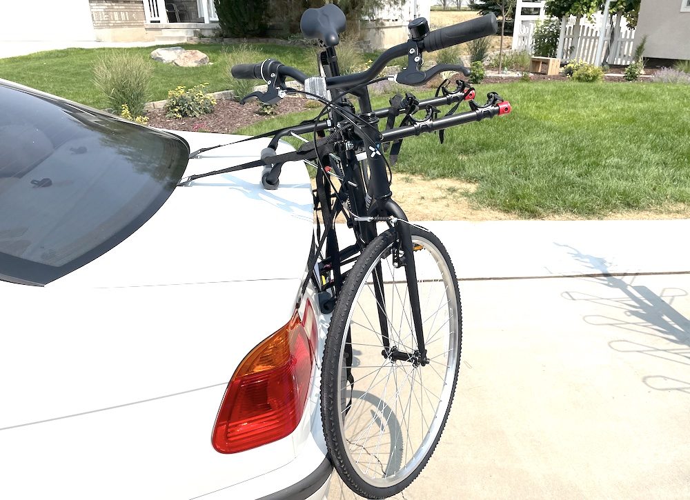 allen sports deluxe trunk bike rack loaded with a black bike on a white car