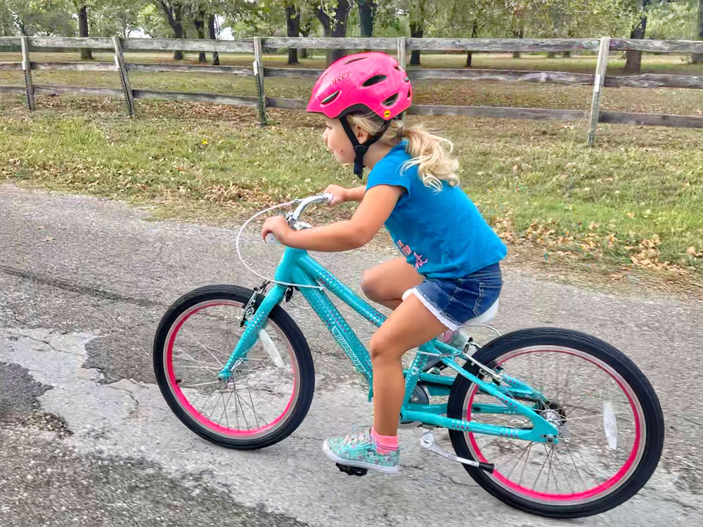 Young girl riding teal Guardian 20 inch small bike