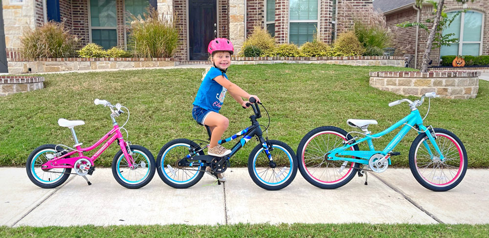Guardian Bikes 14, 16 and 20 small lined up next to each other. Child sitting on the Guardian Bikes 16.