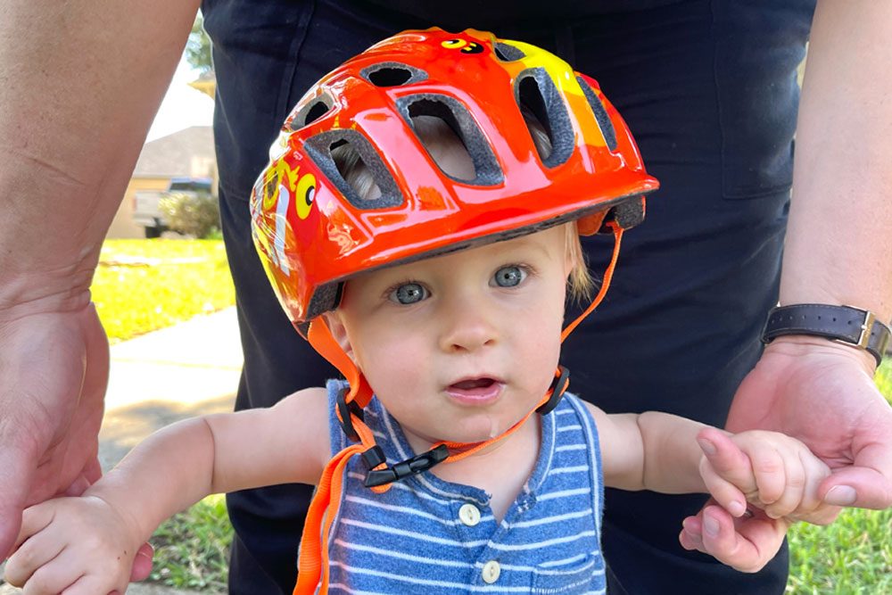 Baby wearing Kali Chakra child helmet that is clearly too big for him