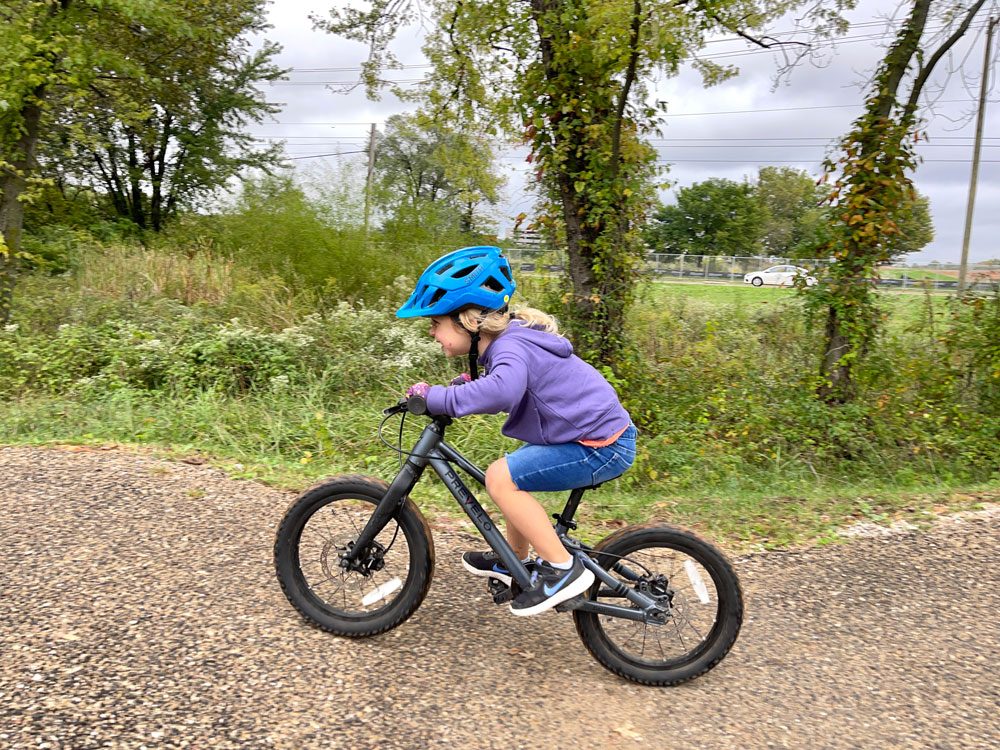 Young girl riding her bike and wearing the Smith Wilder Jr kids helmet