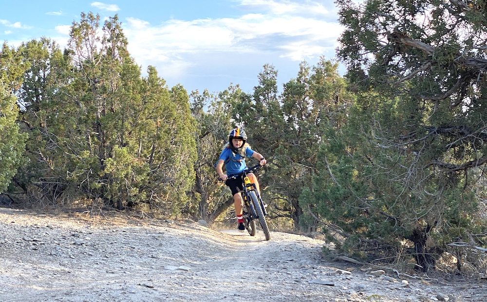 boy riding up a hill on the polygon siskiu kids mountain bike