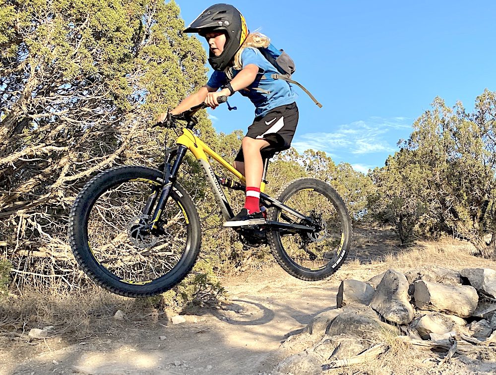 young rider catching air on the polygon siskiu 24 full suspension kids mountain bike