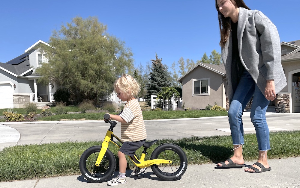 tiny toddler walking a Hornit AIRO balance bike