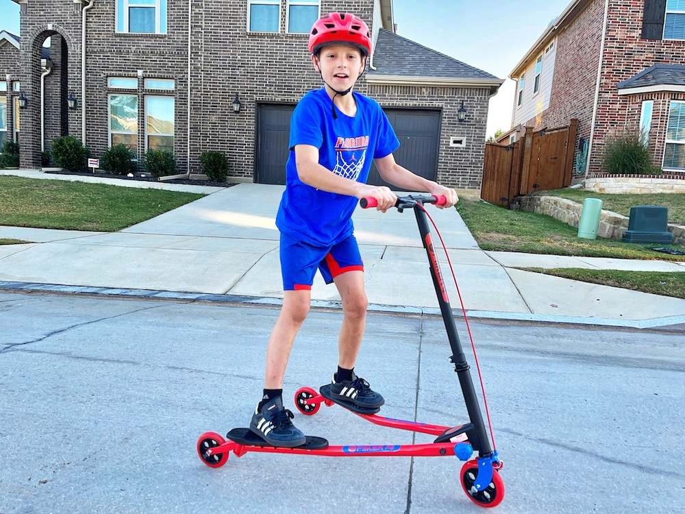 Boy riding Y Fliker A3 wiggle scooter in the street