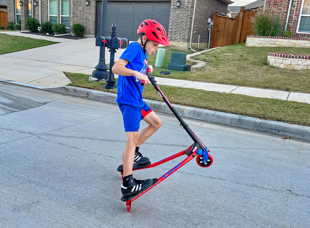 11 year old boy doing a wheelie on the Y Fliker A3 scooter