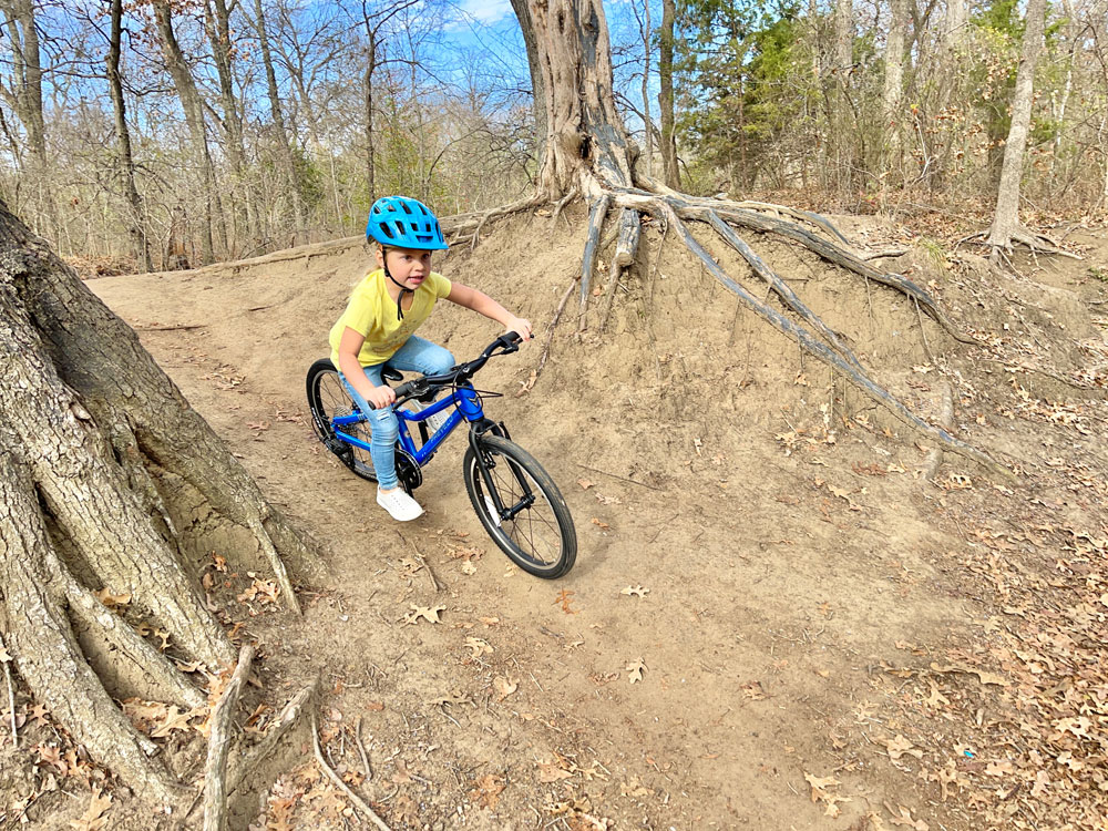 young girl riding the Prevelo Alpha Three on a mountain bike trail