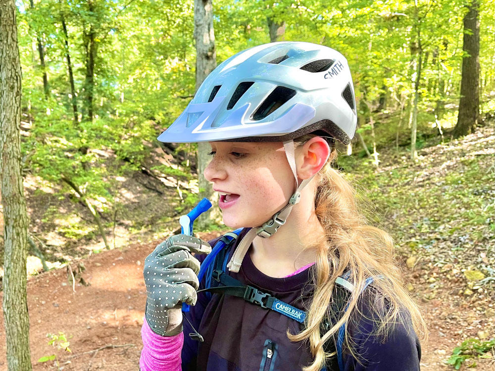 Woman wearing Smith Convoy bike helmet while mountain biking