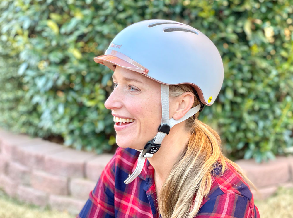 Woman wearing Thousand Chapter helmet in white with rose gold visor