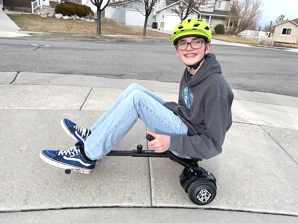 Young boyriding Hover-1 falcon hoverboard go cart in the neighborhood