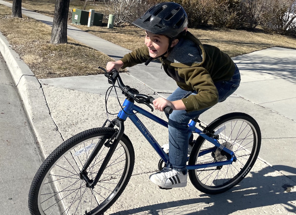 boy happily riding the Prevelo Alpha Four 24 inch bike