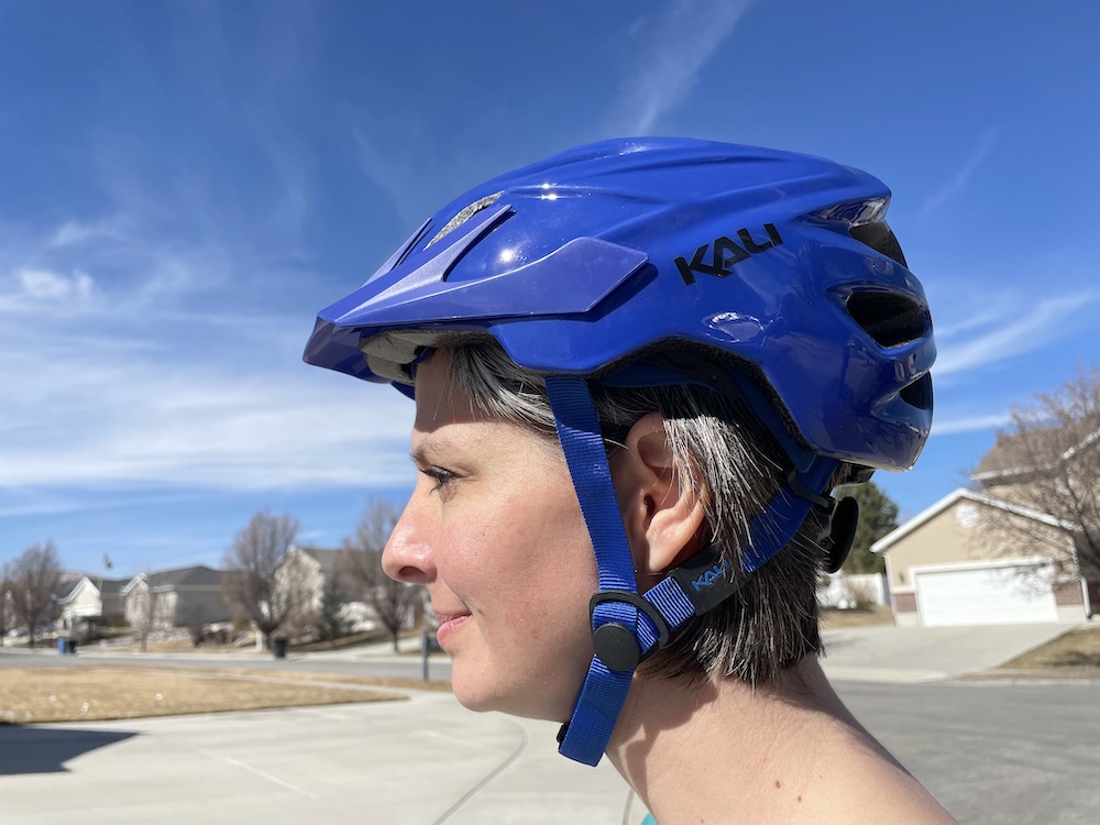 Woman wearing bright blue Kali Chakra Solo helmet