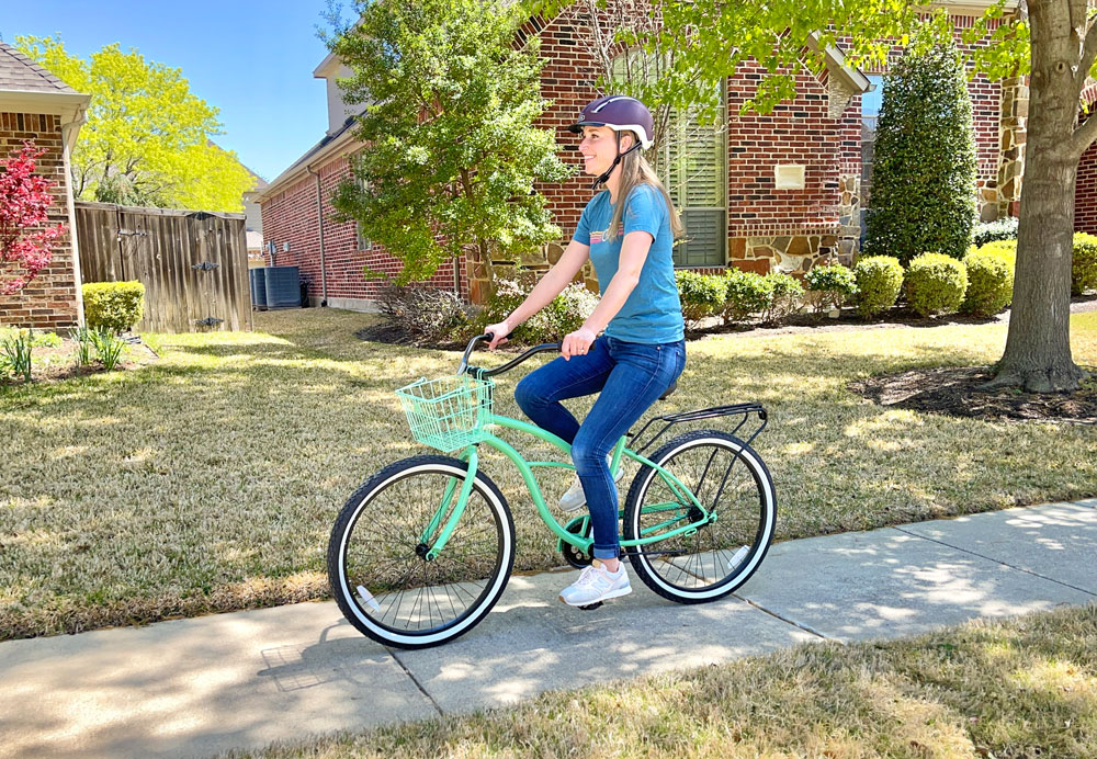 Woman riding SixThreeZero beach cruiser bike through her neighborhood