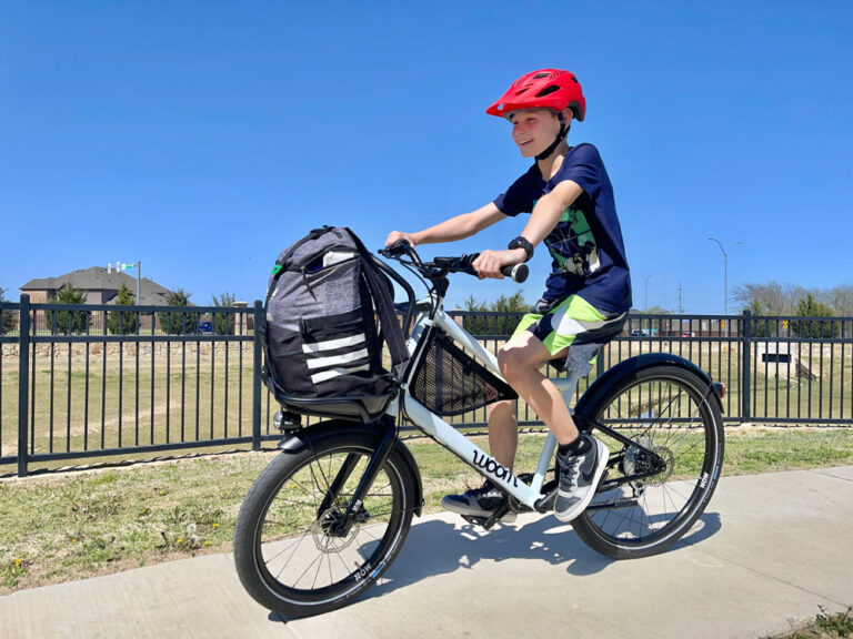11 year old boy riding woom NOW 6 26 inch kids commuter bike on a paved path