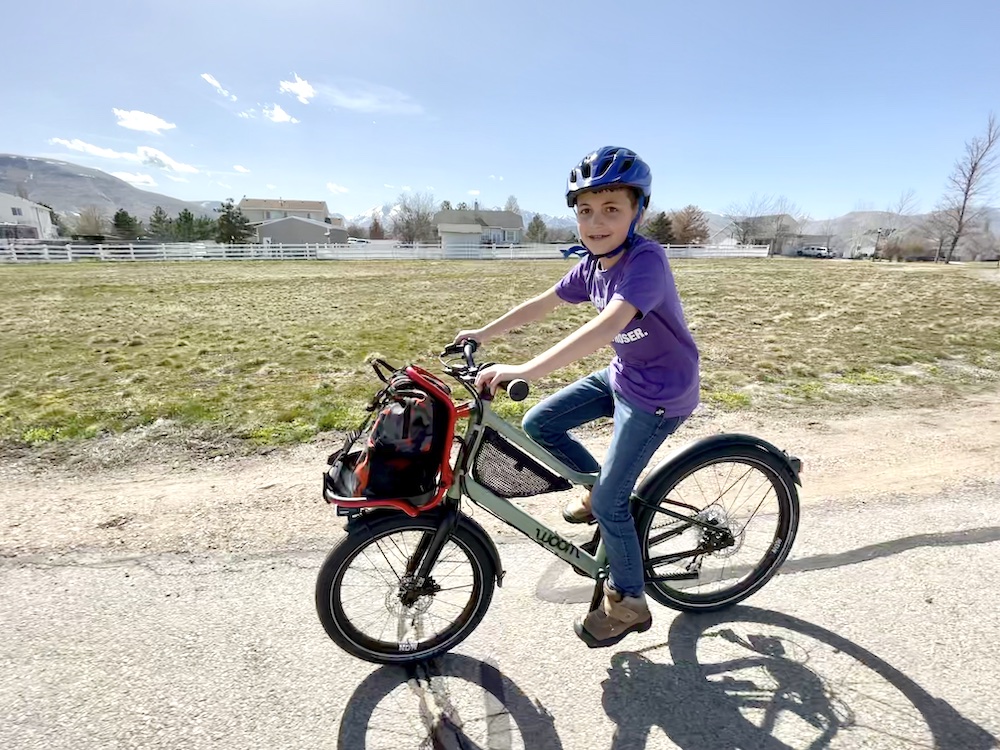 woom NOW kids cargo bike being rid by a 10 year old