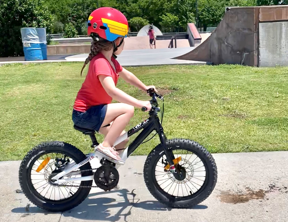 Child riding Commencal Ramones at a lower seat height. Show's tight knee bend at high stroke.