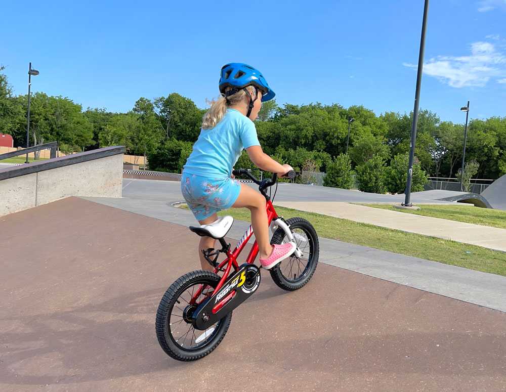 Child climbing up a ramp on the Royalbaby Freestyle 16 inch bike