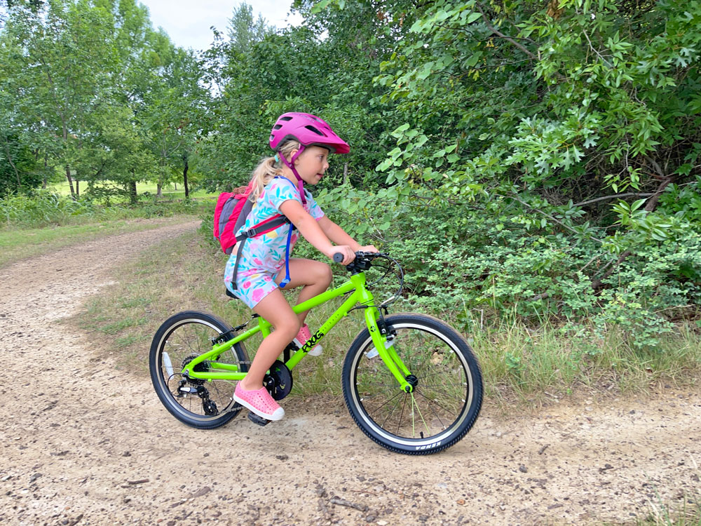 Young girl riding Frog 52 bike on a dirt trail