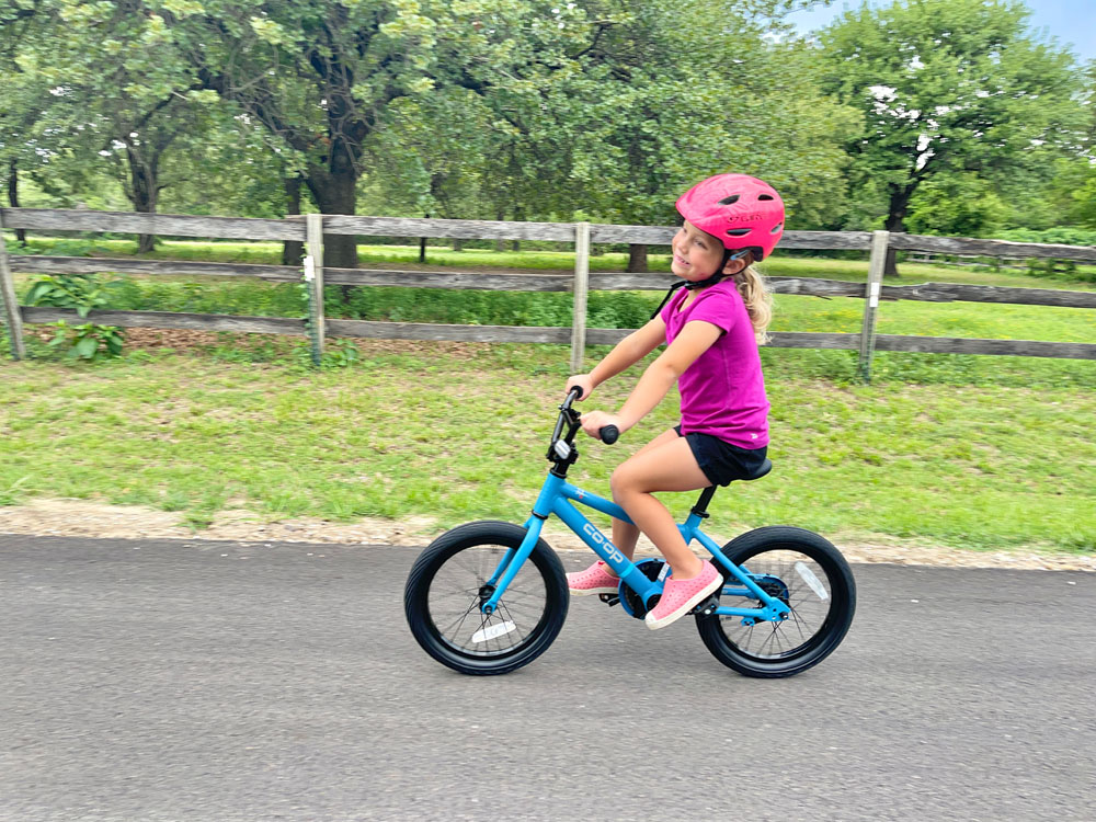 4 year old riding REI REV 16 kids bike down a country road